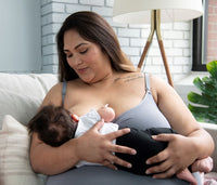 Woman wearing grey seamless nursing tank top nursing her baby
