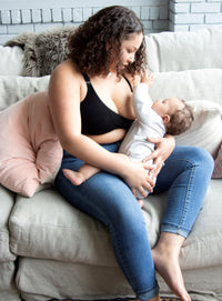 Woman wearing black nursing bra while breastfeeding